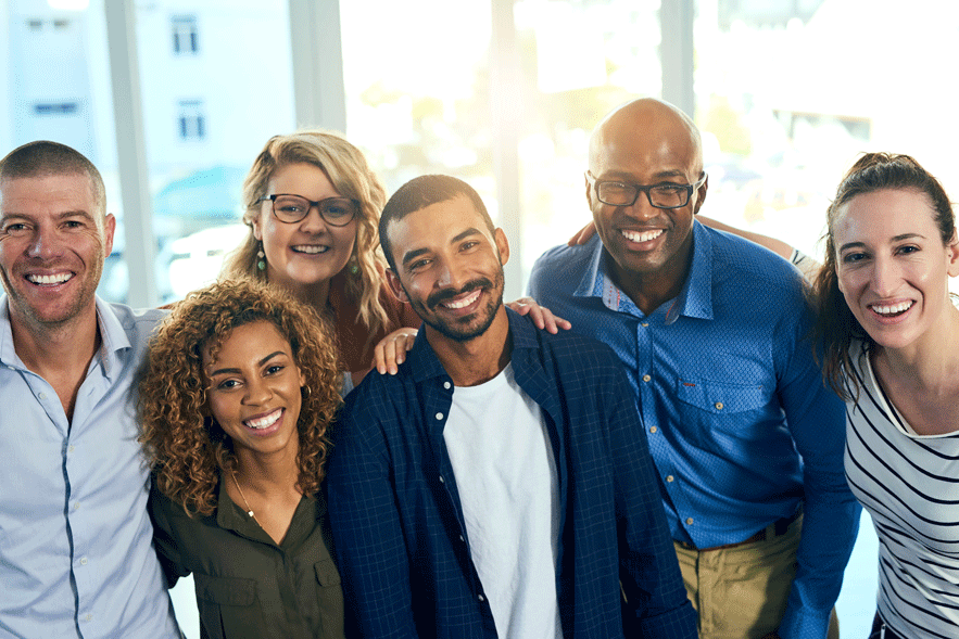 A group of employees standing together, smiling at the camera.